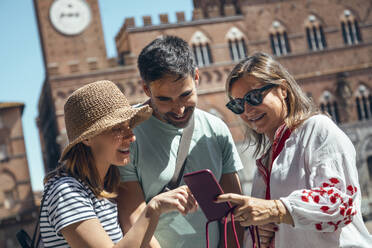Glückliche Touristen teilen ihr Smartphone an einem sonnigen Tag - JSRF02652