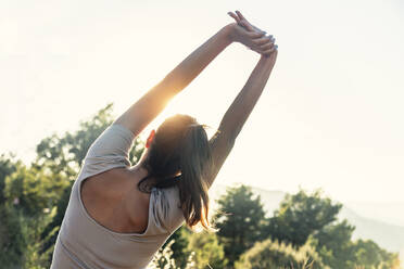 Young woman stretching with arms raised - JSRF02658