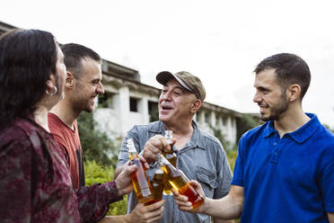 Happy friends toasting beer bottles - JCCMF10831