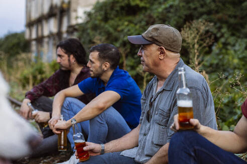 Freunde sitzen mit Bierflaschen - JCCMF10832