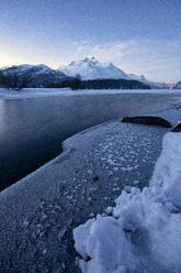 Winter sunrise over the frozen surface of Lake Sils in winter, Engadine, Canton of Graubunden, Switzerland, Europe - RHPLF28494