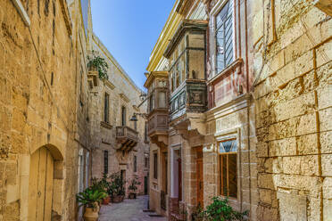Traditional Maltese limestone buildings with coloured balconies in the vibrant alleys of the old city of Birgu (Citta Vittoriosa), Malta, Mediterranean, Europe - RHPLF28508