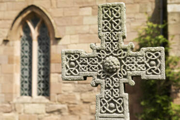 Anglo-Saxon Cross in the churchyard of St. Aidan's Church, a 12th century place of worship and a key location in the introduction of Christianity during Anglo-Saxon times, Bamburgh, Northumberland, England, United Kingdom, Europe - RHPLF28645