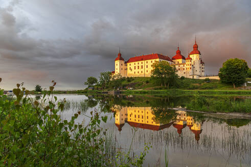 Lacko Castle and the reflection in the water at sunset, Kallandso island, Vanern lake, Vastra Gotaland, Sweden, Scandinavia, Europe - RHPLF28651