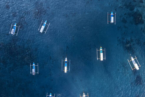 Aeria view of traditional empty fishing boats in the blue water of Gili Trawangan, Gili Islands, West Nusa Tenggara, Pacific Ocean, Indonesia, Southeast Asia Asia - RHPLF28663