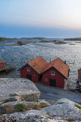 Wooden houses on rocky coast at dusk, Bohuslan, Vastra Gotaland, Sweden, Scandinavia, Europe - RHPLF28665