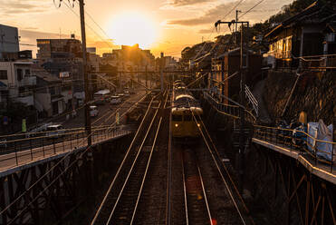 View from a railway bridge with a yellow Japanese train approaching during sunset, Onomichi, Honshu, Japan, Asia - RHPLF28681