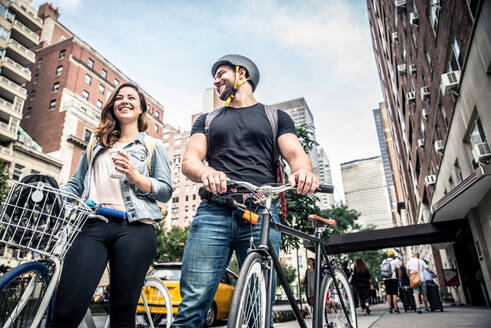 Couple of cyclist in New York - Couple of lovers sighseeing Manhattan on bikes - DMDF07425