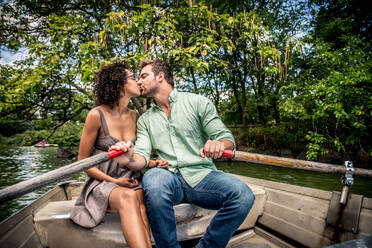 Happy couple having fun on a boat in Central Park - Interracial couple of tourists sighseeing Manhattan - DMDF07435