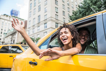 Interracial couple driving on a taxi in Manhattan - Tourists sightseeing New York on a yellow cab - DMDF07442