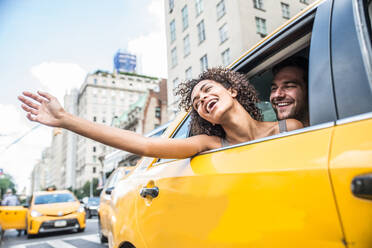 Interracial couple driving on a taxi in Manhattan - Tourists sightseeing New York on a yellow cab - DMDF07444