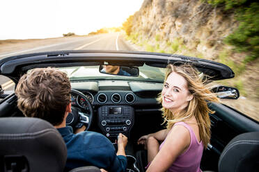 Couple of lovers driving on a convertible car - Newlywed pair on a romantic date - DMDF07447