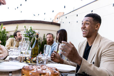 Storytelling footage of a multiethnic group of people dining on a rooftop. Family and friends make a reunion at home - DMDF07466