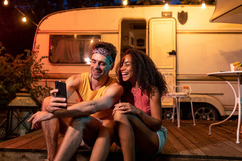 Junges Paar im Urlaub mit dem Wohnmobil, das die Nacht in der Natur genießt. Konzept über Fernweh, Roadtrips und Lifestyle im Urlaub - DMDF07479