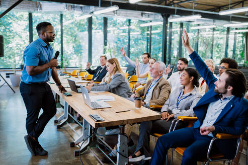 Cinematic image of a conference meeting. Business people sitting in a room listening to the motivator coach. Representation of a Self growth and improvement special event - DMDF07500