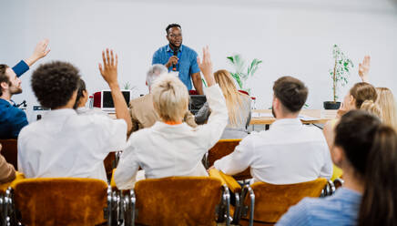 Filmische Darstellung einer Konferenz, bei der Geschäftsleute in einem Raum sitzen und einem Motivationscoach zuhören. Darstellung einer speziellen Veranstaltung zum Thema Selbstwachstum und Verbesserung - DMDF07501