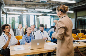 Cinematic image of a conference meeting. Business people sitting in a room listening to the motivator coach. Representation of a Self growth and improvement special event - DMDF07502