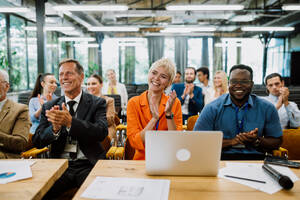 Cinematic image of a conference meeting. Business people sitting in a room listening to the motivator coach. Representation of a Self growth and improvement special event - DMDF07516