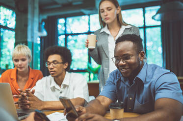 Cinematic image of people working in a start up business. Multiethnic team of experts working together to develop the new projects - DMDF07526