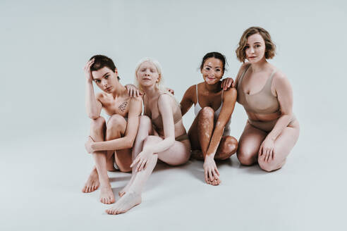 Group of multiethnic women with different kind of skin posing together in studio. Concept about body positivity and self acceptance - DMDF07554