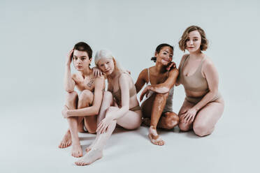 Group of multiethnic women with different kind of skin posing together in studio. Concept about body positivity and self acceptance - DMDF07555