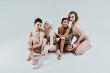 Group of multiethnic women with different kind of skin posing together in studio. Concept about body positivity and self acceptance - DMDF07556
