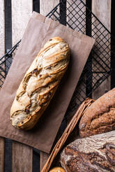 Top view of wholegrain bread loaf with crispy crust placed on tray on table - ADSF48070