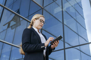 Geschäftsfrau mit Smartphone vor Bürogebäude - OSF02266