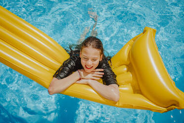 Girl leaning on pool raft at sunny day - MDOF01581