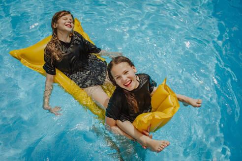 Glückliches Mädchen genießt mit Freund auf Pool Floß am sonnigen Tag - MDOF01585
