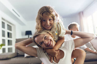 Happy mother with daughter in living room - JSRF02698