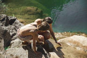 Mutter und Sohn spielen mit Wasser am Fluss - PCLF00767