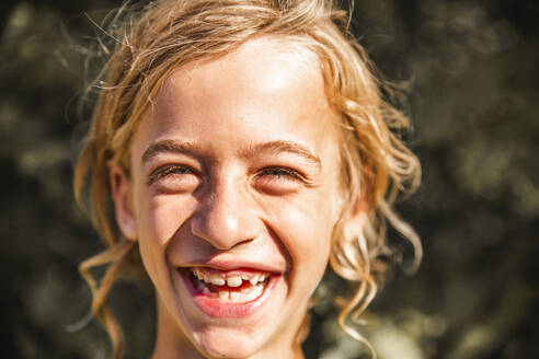 Lächelnder blonder Junge an einem sonnigen Tag - PCLF00778