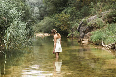 Frau steht im Fluss im Wald - PCLF00791