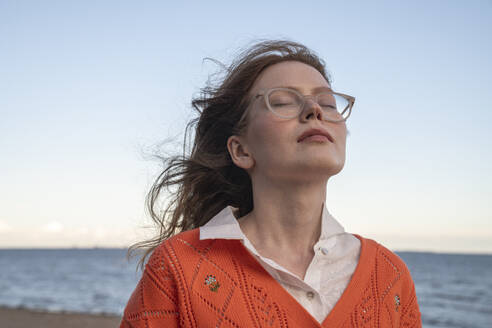 Young woman with eyes closed in front of sea - VPIF08864