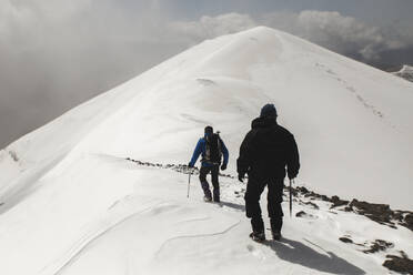 Männer wandern auf einem schneebedeckten Berg - PCLF00851