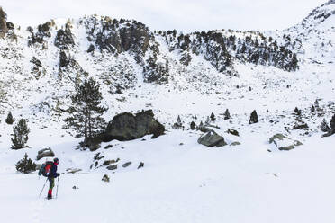 Man hiking with pole on snowcapped mountain - PCLF00856