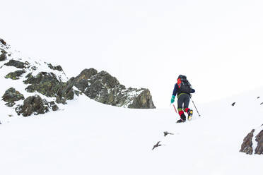 Man walking with pole on mountain in winter - PCLF00858