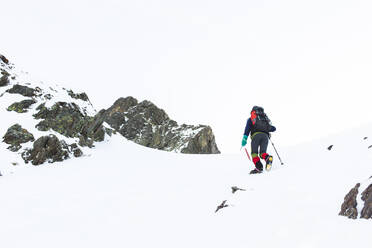 Mann geht mit Stock auf Berg im Winter - PCLF00858