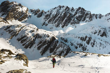 Mann wandert auf verschneitem Berg im Winter - PCLF00859