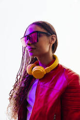 Young woman with braided hair wearing sunglasses and headphones in tunnel - OIPF03543