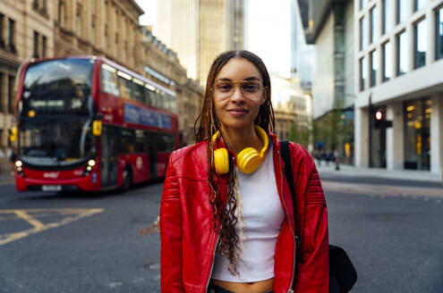 Fashionable young woman with braided hair standing on road in city - OIPF03561