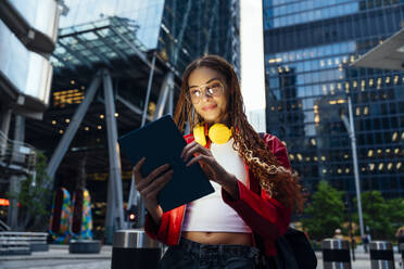 Junge Frau mit Kopfhörern und Tablet-PC in der Stadt - OIPF03565