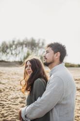 Loving couple together standing at beach on sunny day - ANAF02245