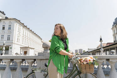 Woman with bicycle in front clear sky - NDEF01182