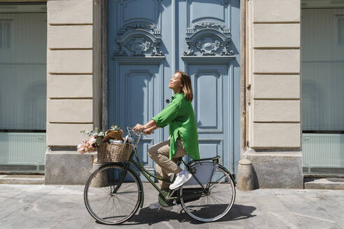 Frau fährt am Wochenende mit Fahrrad auf Fußweg - NDEF01187