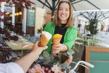 Freunde essen Eiswaffeln in einem Straßencafé - NDEF01191