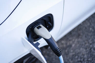 Electric car charging with plug at station - DIGF20879