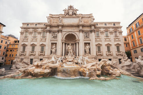 Famous iconic Trevi Fountain at Piazza Di Trevi in Rome city in Italy against cloudy sky - ADSF48179