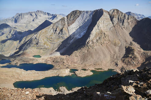 From above scenic view of calm lake surrounded by Picos del Infierno mountain range against blue sky in the Aragonese Pyrenees in Spain - ADSF48183